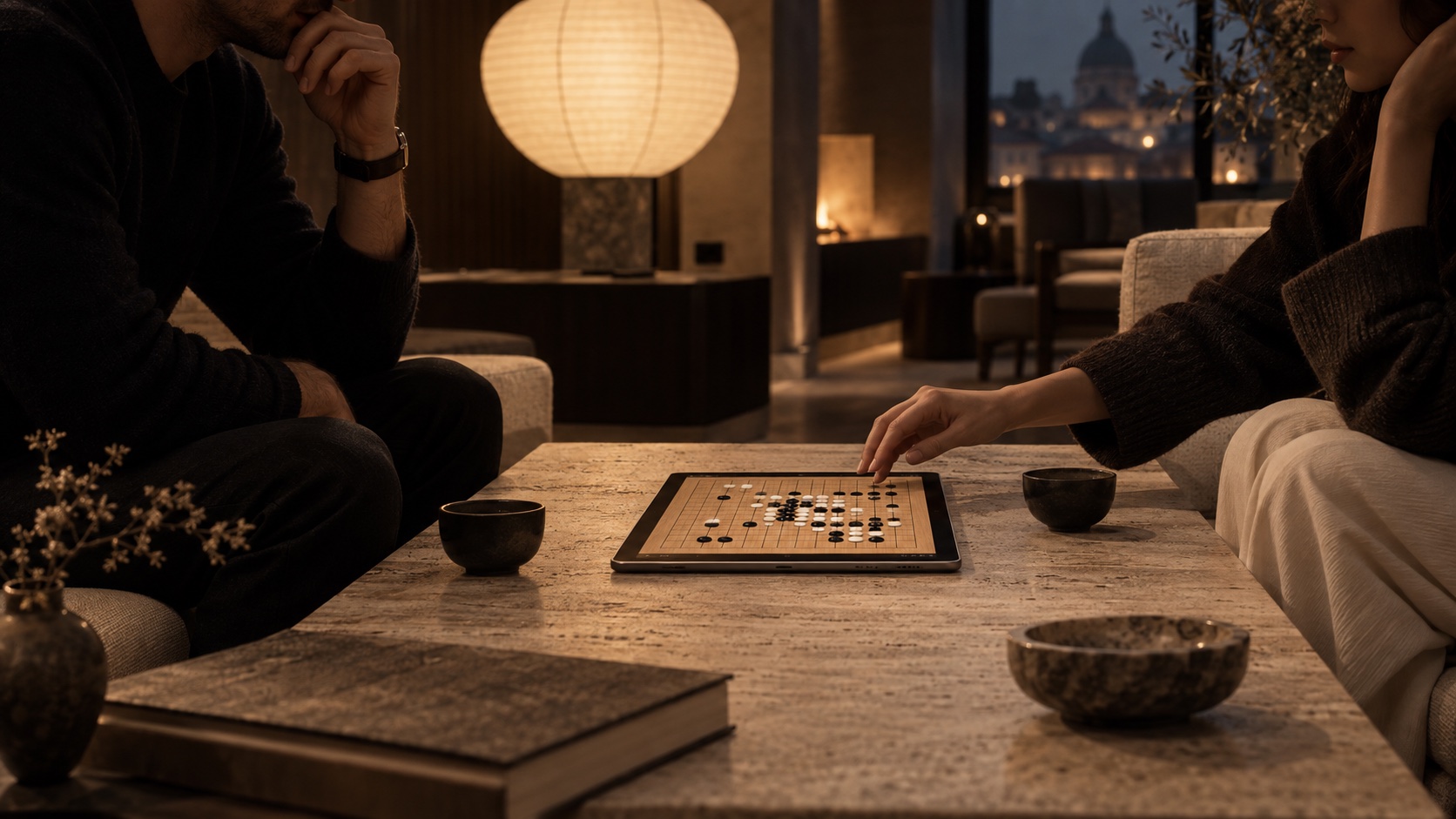 Two people playing Kanso Go in a warmly lit hotel lounge